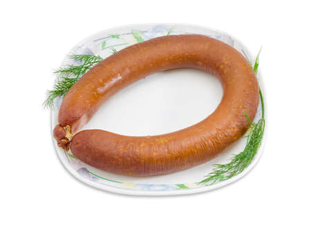 Ring sausage in natural casing with two branches of dill on a white dish with ornament on a light background. Isolation.の写真素材