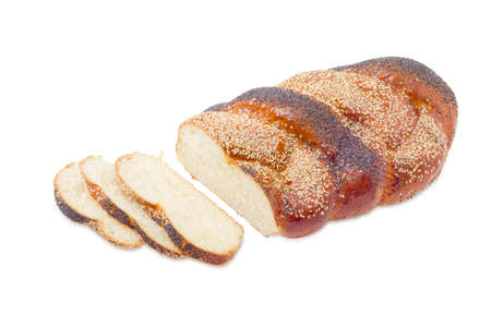 Part of a braided bun, sprinkled with poppy seeds and sesame seeds and several slices of a bun on a...