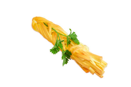 Smoked chechil cheese in the form of strings, rolled up in a figure of braided shaped ropes and a sprig of parsley on a light backgroundの写真素材
