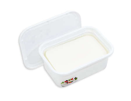 Rectangular container of feta cheese in a brined with the cover removed on a light backgroundの写真素材