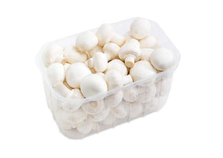 Fresh uncooked button mushrooms in a transparent plastic tray on a light backgroundの写真素材