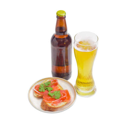Beer glass with lager beer, bottle beer and two sandwiches made with a salted trout on a light backgroundの写真素材