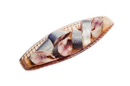 Pickled atlantic herring in pink glass herring-dish on a light backgroundの写真素材