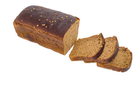 Part of loaf brown bread from rye and wheat flour sprinkled with coriander seeds and several slices of bread on a light backgroundの写真素材