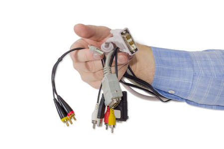 Several various cables with connectors for computers and other gadgets in a man's hand on a light backgroundの写真素材