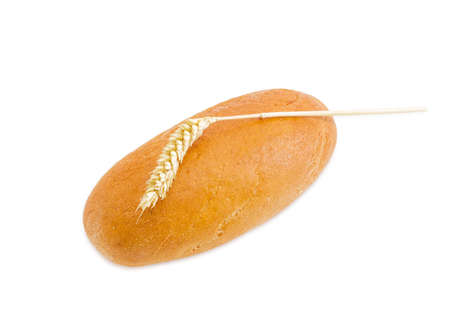 Whole oval loaf of wheat bread and spike of ripe wheat on a light backgroundの写真素材