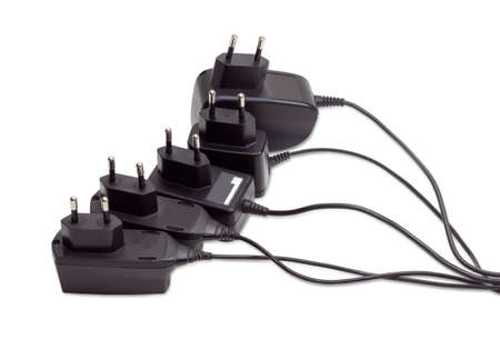Several various battery chargers with various connectors for mobile phone and other gadgets on a light backgroundの写真素材