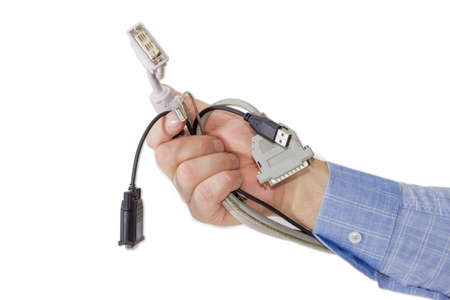 Several various cables with connectors for computers technology in a man's hand on a light backgroundの写真素材