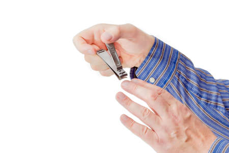 Nail clipper in the compound lever style made of stainless steel in male hands on a light backgroundの写真素材