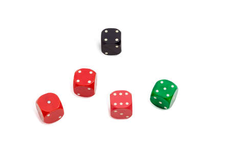 Old standard plastic multi colored six-sided dice with rounded corners on a light backgroundの写真素材
