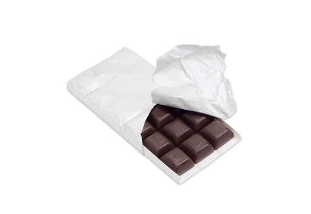 Slices of dark chocolate in the opened packaging made of foil on a light backgroundの写真素材