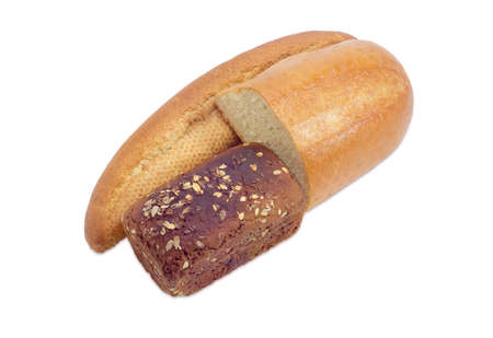 Whole long roll of bread with bran, brown whole wheat bread with grains of flax and sunflower and half of a loaf wheat bread on a light backgroundの写真素材