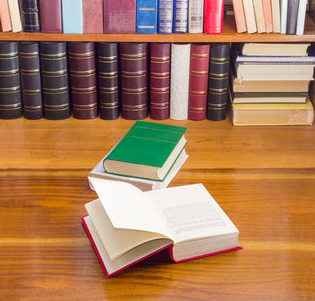 Open book, stack of two books different formats and cover design on a wooden table against the...