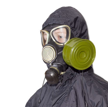 Head and shoulders of a person in a rubber gas mask with filter mounted on side of the mask and drinking tube and in a black jacket with a hood on a light backgroundの写真素材