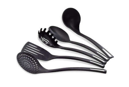 Set of plastic black cooking utensils consisting of skimmer, fish slice, slotted spoon, kitchen spoon and soup ladle on a light backgroundの写真素材