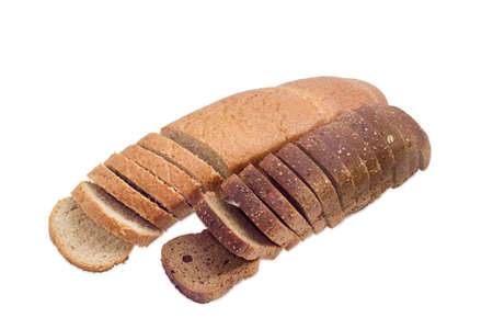 One partly sliced long loaf of wheat bread with bran and sliced brown bread with whole grain on a...