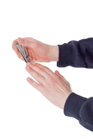 Nail clipper in the compound lever style made of stainless steel in male hands during trimfinger nails on a light backgroundの写真素材