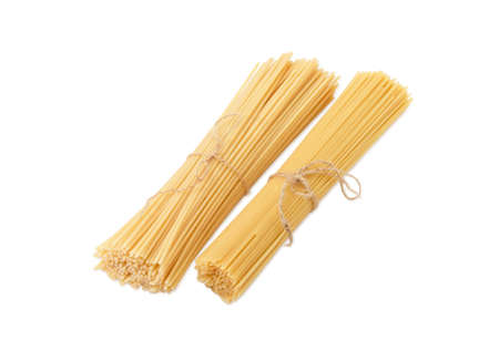 Two bundles of different uncooked dried long pasta on a light backgroundの写真素材