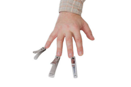 Three nail clippers different sizes in the compound lever style opposite the fingers of a male hand on a light backgroundの写真素材