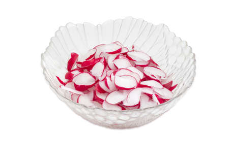Fresh sliced red radish in transparent glass salad bowl on a light backgroundの写真素材