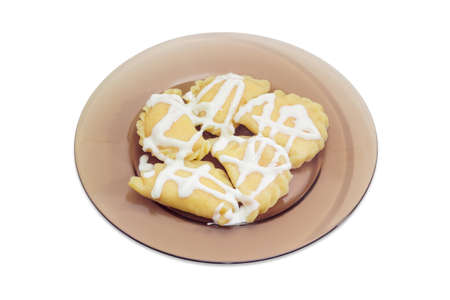 Varenyky (dumplings) with cottage cheese pour with sour cream in a dark glass dish on a light backgroundの写真素材