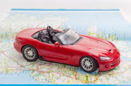 Children's red toy car cabriolet on the open road atlasの写真素材