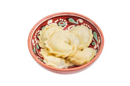 Varenyky (dumplings) with fruit filling sprinkled with sugar in a ceramic bowl on a light backgroundの写真素材
