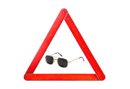 Pinhole glasses among warning triangle sign with red border on a light backgroundの写真素材