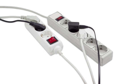 One power strip with illuminated switch, one power strip with power circuit breaker and built-in surge protector and several various power plugs with mains cables on a light backgroundの写真素材