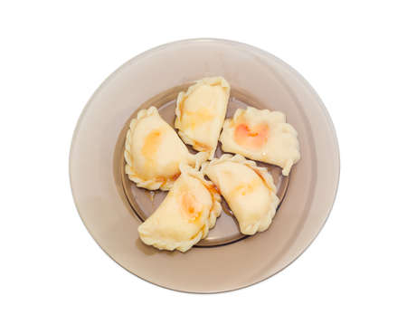 Varenyky (dumplings) with cottage cheese poured on with jam in a dark glass dish on a light backgroundの写真素材