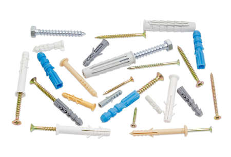 Chipboard screws and plastic wall plugs of different sizes and colors on a light backgroundの写真素材