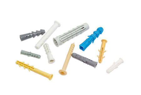 Plastic wall plugs of different sizes and colors on a light background
