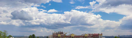 Panorama sky with cumulus clouds over the outskirts of the modern city summer dayの写真素材