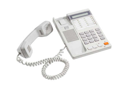 Landline telephone with push button dial, digital display and removed handset on a light backgroundの写真素材