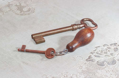 Two ancient keys from door locks with copper coating on the old tableclothの写真素材