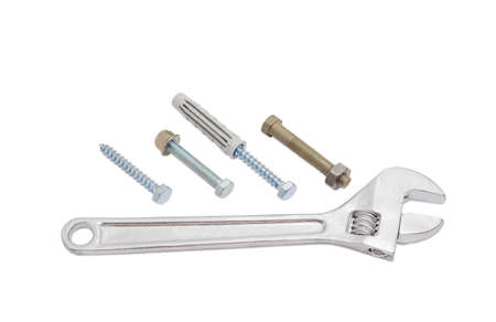 Adjustable wrench next to the bolts with with a hex nut, lag screws and plastic wall plug on a light backgroundの写真素材