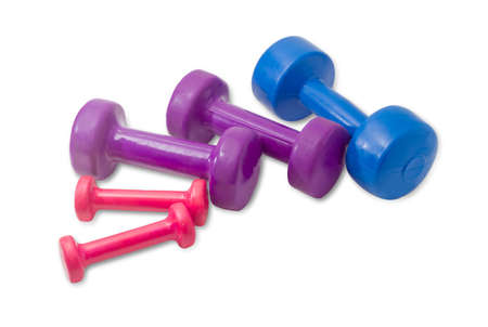 Several fixed weight dumbbells different weight and sizes coated with vinyl of various colors on a light backgroundの写真素材