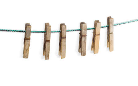 Old spring type wooden clothespin on a clothes line on a light backgroundの写真素材