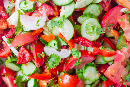 Background of salad with fresh sliced tomatoes, cucumbers, bell pepper, onion, herbsの写真素材