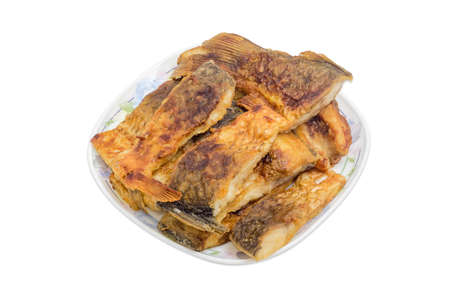 White dish, filled with pieces of fried carp on a light backgroundの写真素材
