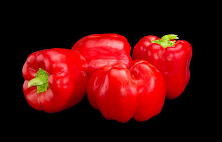 Several fresh red bell peppers on a dark backgroundの写真素材