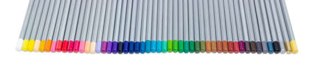 Fragment of set of colored pencils in gray wooden case, laid in a row on a light backgroundの写真素材