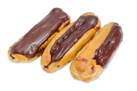 Three eclairs with chocolate icing on a light backgroundの写真素材