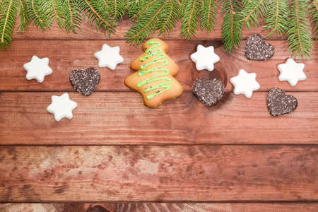 Background of wooden surface made of the dark pine planks with different cookies and fir branches at the topの写真素材