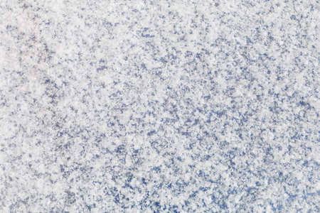 Background of a blue surface covered with a thin layer of a newly fallen fluffy snowの写真素材