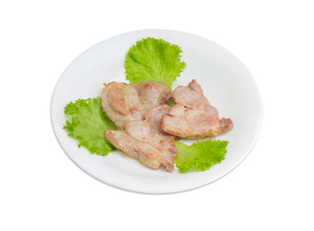 Three slices of fried pork neck on lettuce leaves on white dish on a light backgroundの写真素材
