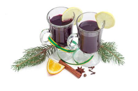 Mulled wine in two glass mug with slice of lemon, mulling spices for cooking mulled wine and two fir branches on a light backgroundの写真素材