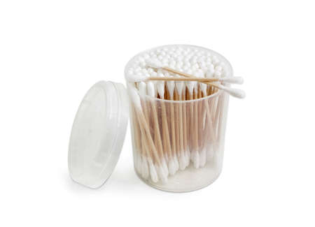 Cotton swabs on a wooden rods in transparent round plastic container on a light backgroundの写真素材