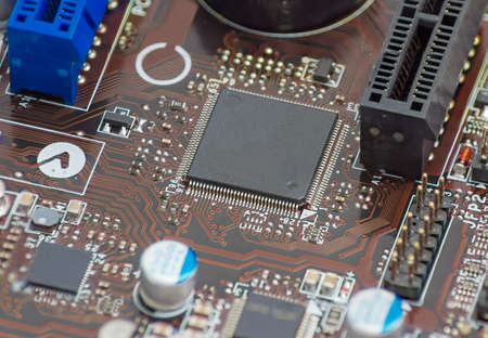 Fragment of printed circuit assembly with surface mounted chip in center and other electronic...