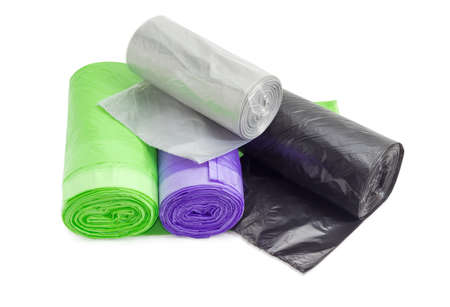 Several plastic disposable garbage bags of different sizes and colors in rolls including biodegradable on a light backgroundの写真素材